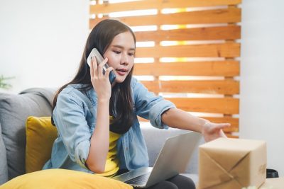 Young woman talking on the phone to customer service.